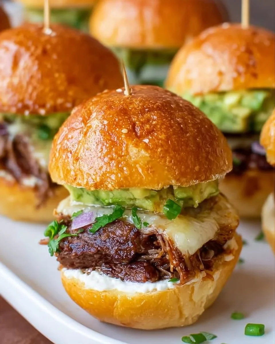 Delicious beef sliders with horseradish spread served on a wooden platter.