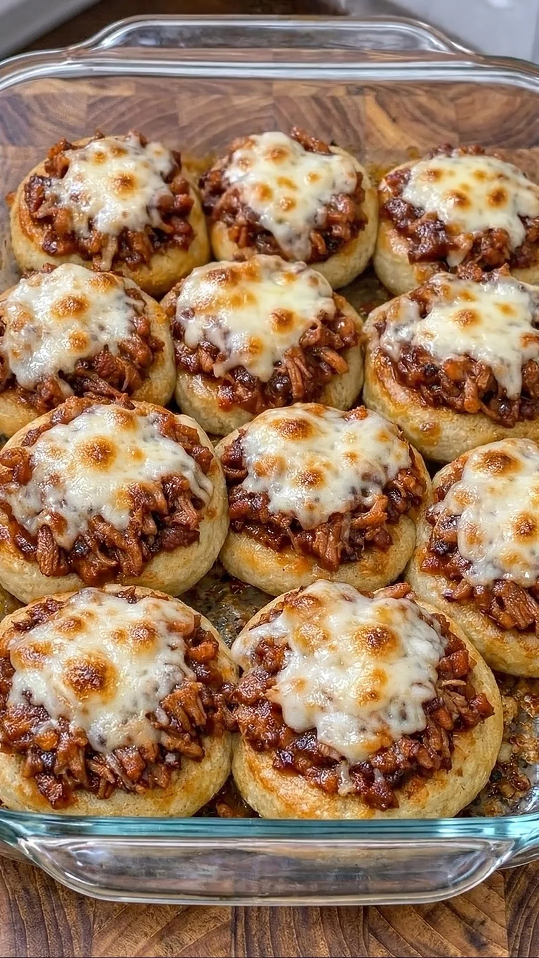 Cheesy BBQ chicken biscuit cups topped with melted cheese and BBQ sauce